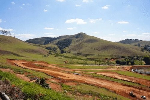 Vias abertas em terra no Vale dos Passos com rolo compactador em operação, em Bicas/MG